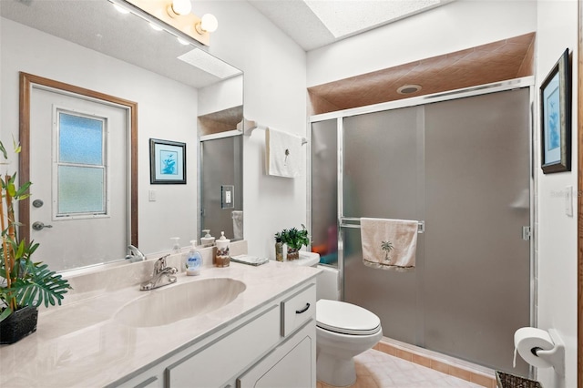 bathroom featuring a shower with door, vanity, a textured ceiling, and toilet