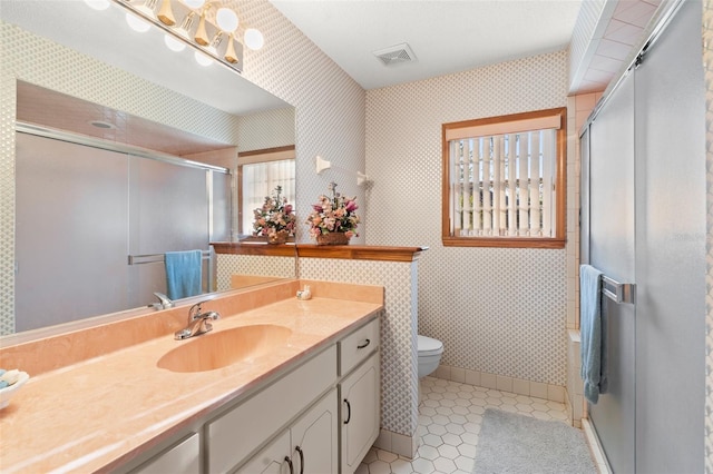 bathroom featuring vanity, toilet, and a shower with shower door