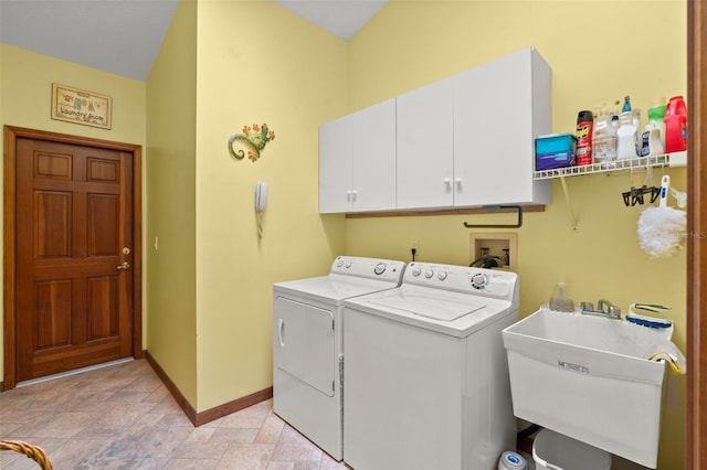 laundry area with cabinets, separate washer and dryer, and sink