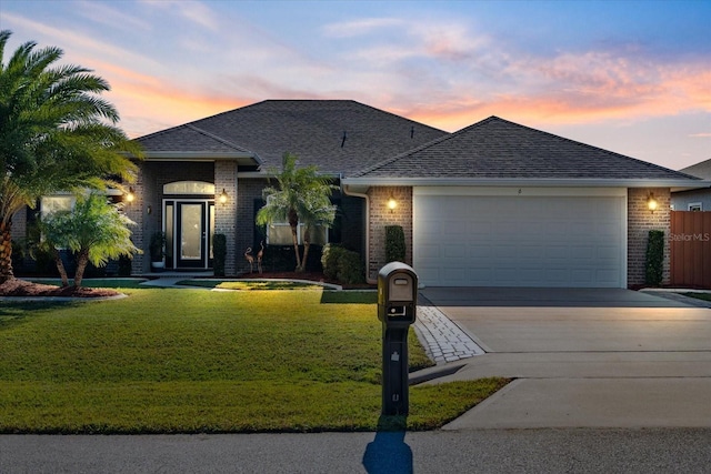 ranch-style house featuring a yard and a garage