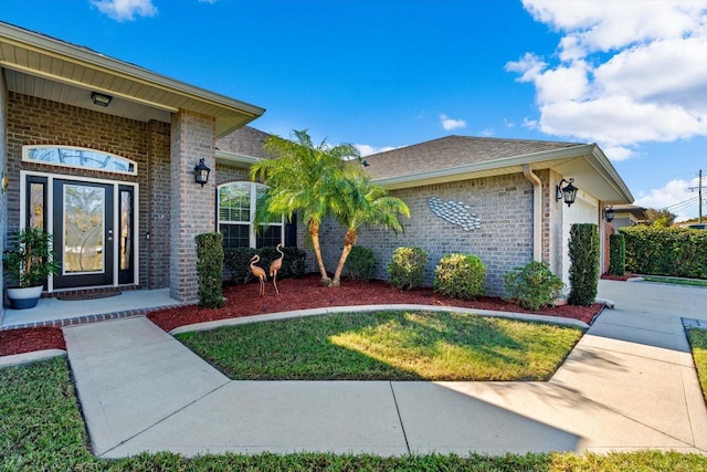6 Lindsay Dr, Palm Coast, FL 32137 - view of front of property with brick siding, a garage, a shingled roof, and a front lawn