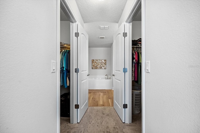 6 Lindsay Dr, Palm Coast, FL 32137 - corridor featuring a textured ceiling, carpet flooring, and a textured wall