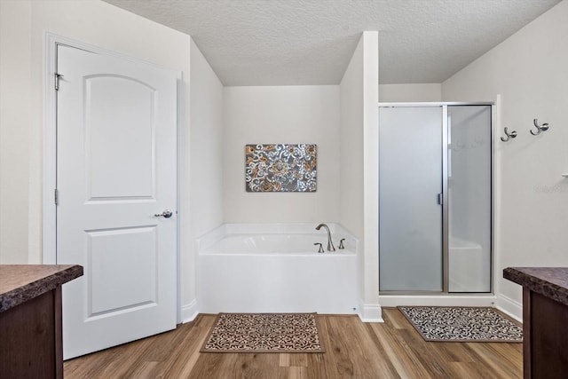 6 Lindsay Dr, Palm Coast, FL 32137 - full bathroom featuring wood finished floors, a shower stall, vanity, a bath, and a textured ceiling