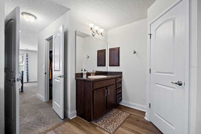 6 Lindsay Dr, Palm Coast, FL 32137 - bathroom featuring a textured ceiling, vanity, wood finished floors, and baseboards
