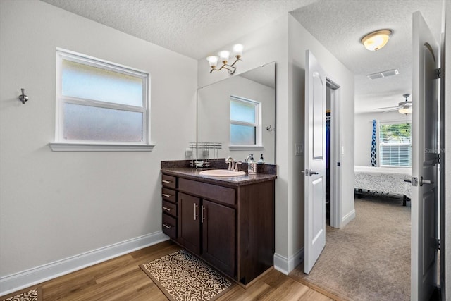 6 Lindsay Dr, Palm Coast, FL 32137 - bathroom with vanity, a textured ceiling, ensuite bath, wood finished floors, and baseboards