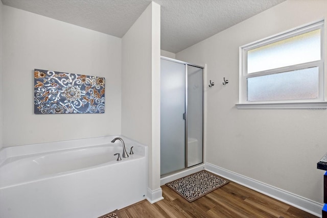 6 Lindsay Dr, Palm Coast, FL 32137 - bathroom featuring wood finished floors, baseboards, a bath, a stall shower, and a textured ceiling