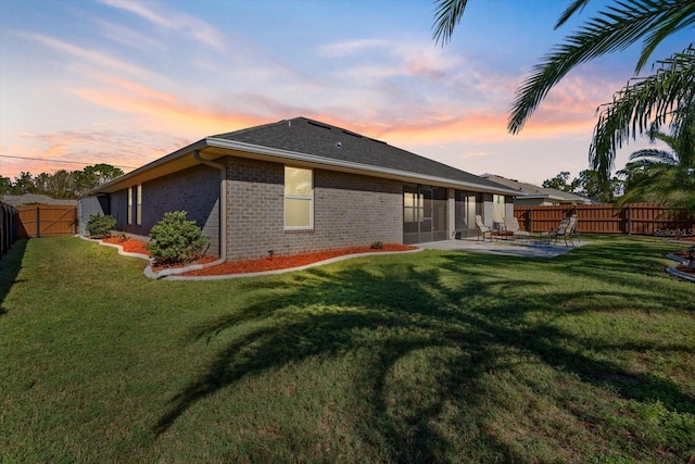 6 Lindsay Dr, Palm Coast, FL 32137 - back of house at dusk featuring brick siding and a patio