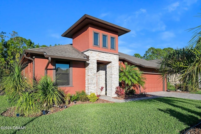 view of front of house featuring a garage and a front lawn