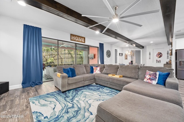 living room featuring beamed ceiling, ceiling fan with notable chandelier, and hardwood / wood-style flooring