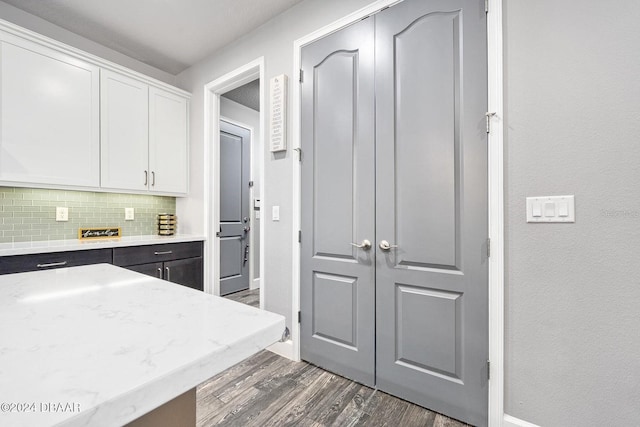 kitchen with dark hardwood / wood-style floors, white cabinetry, and tasteful backsplash