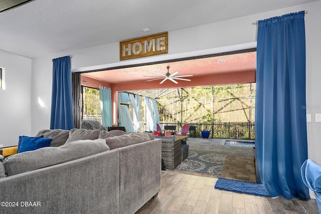 living room featuring hardwood / wood-style floors, a textured ceiling, and ceiling fan