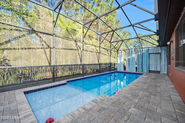 view of swimming pool featuring a lanai