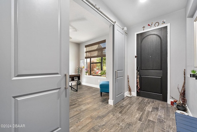 entryway with a barn door and dark hardwood / wood-style floors