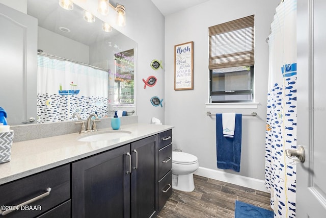 bathroom featuring toilet, vanity, and hardwood / wood-style flooring