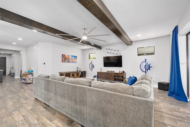 living room featuring beamed ceiling, hardwood / wood-style flooring, and ceiling fan