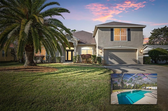 view of front property with a garage and a lawn