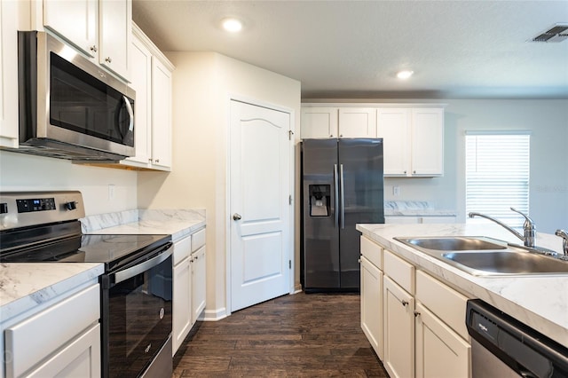 kitchen featuring appliances with stainless steel finishes, dark hardwood / wood-style flooring, a textured ceiling, sink, and white cabinetry