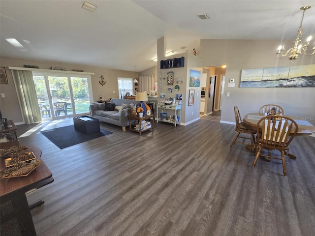 living room featuring dark hardwood / wood-style flooring, a chandelier, and vaulted ceiling