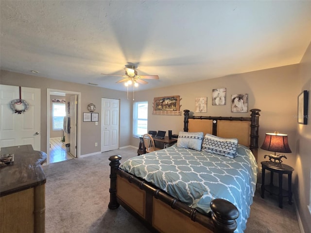 carpeted bedroom with multiple windows and ceiling fan