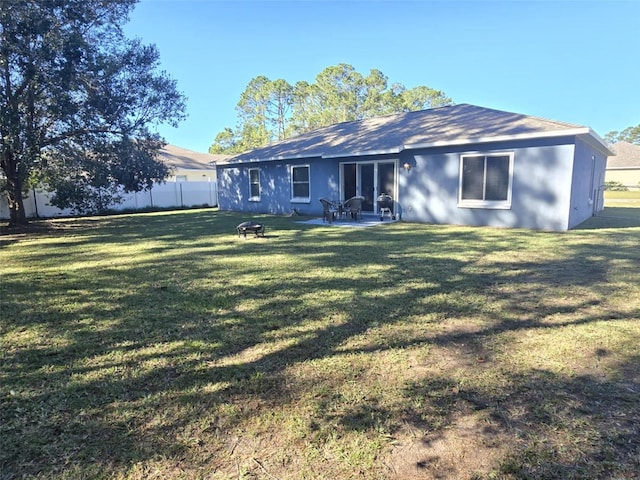 rear view of property featuring a lawn