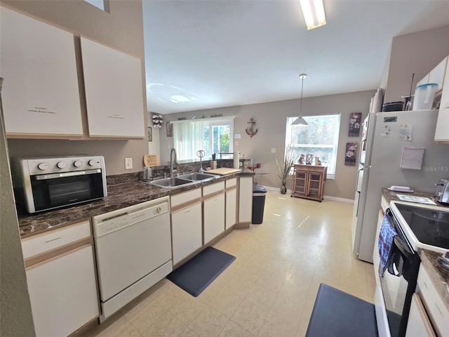 kitchen featuring pendant lighting, sink, white appliances, and white cabinets