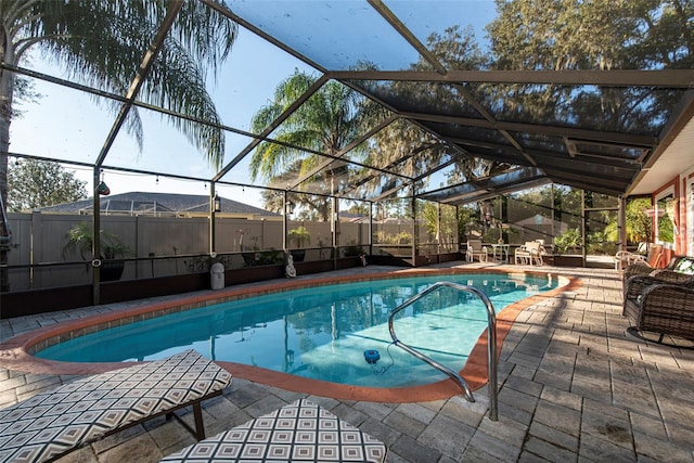 view of swimming pool featuring a patio area and glass enclosure