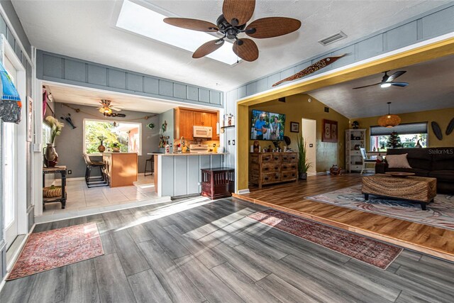 14 Fort Caroline Ln, Palm Coast, FL 32137 - living area featuring ceiling fan, light wood finished floors, healthy amount of natural light, and vaulted ceiling