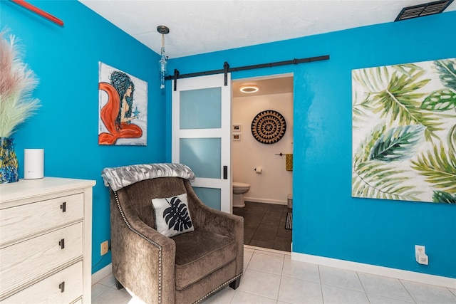 14 Fort Caroline Ln, Palm Coast, FL 32137 - sitting room featuring a barn door, light tile patterned floors, and baseboards