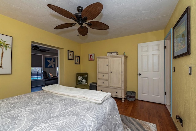 bedroom with a textured ceiling, dark hardwood / wood-style flooring, and ceiling fan