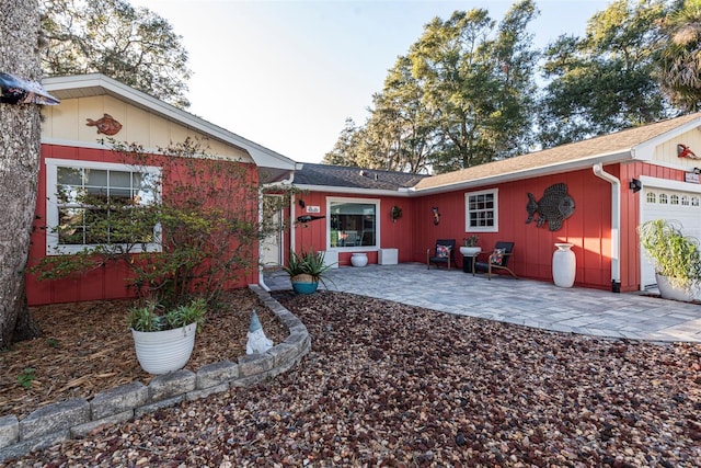 back of house featuring a patio and a garage