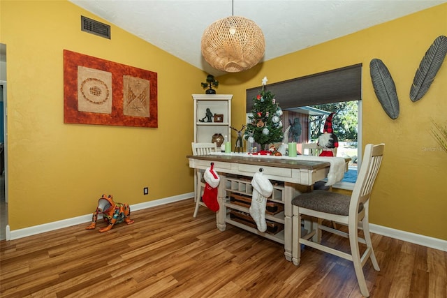 dining space featuring hardwood / wood-style flooring and lofted ceiling