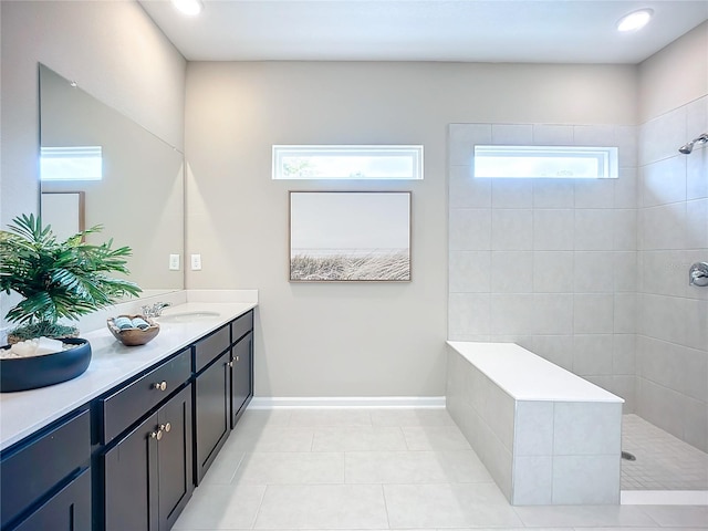 bathroom with tile patterned flooring, a tile shower, and vanity