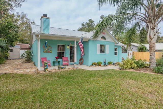 view of front of home with a front yard and a shed