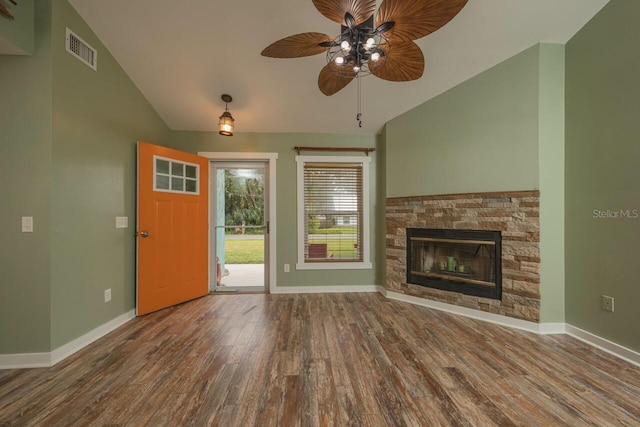 unfurnished living room featuring ceiling fan, a stone fireplace, wood-type flooring, and lofted ceiling