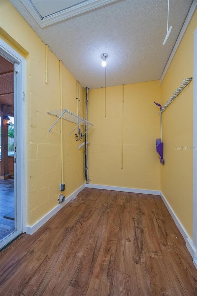 laundry area with a textured ceiling and hardwood / wood-style flooring