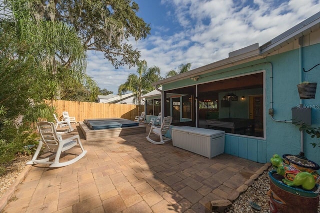 view of patio / terrace featuring a sunroom and a covered hot tub