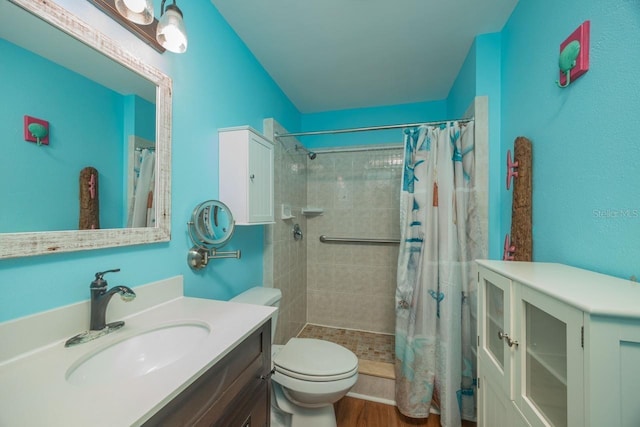 bathroom featuring curtained shower, hardwood / wood-style floors, vanity, and toilet