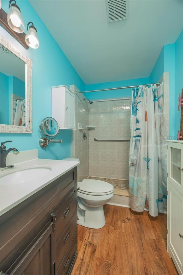 bathroom featuring hardwood / wood-style floors, toilet, and walk in shower