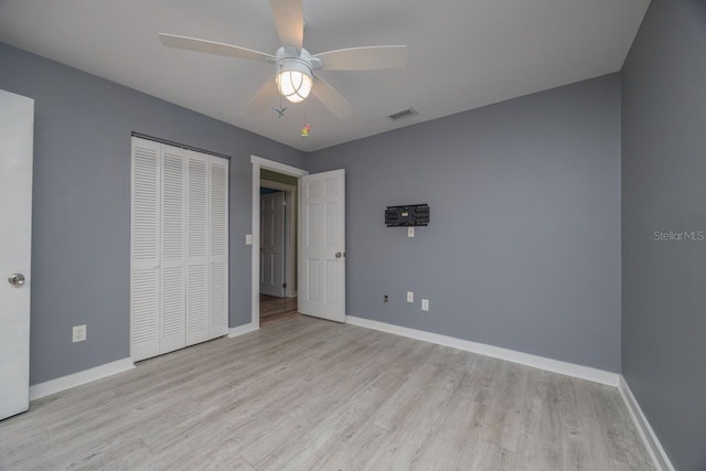 unfurnished bedroom with ceiling fan, light hardwood / wood-style flooring, and a closet