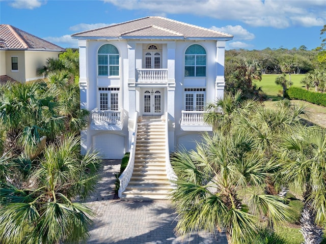 mediterranean / spanish-style house featuring a garage and french doors