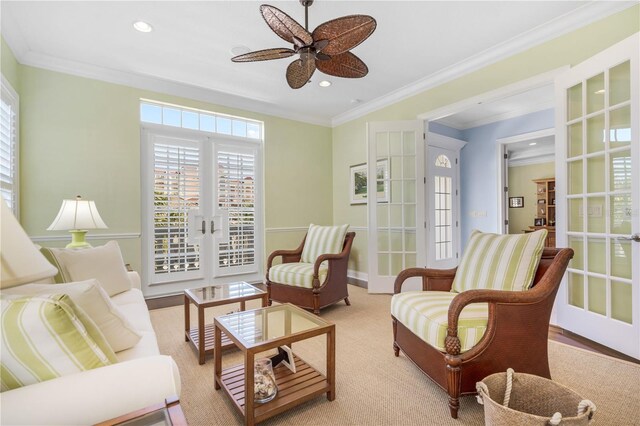 sitting room with plenty of natural light, ceiling fan, crown molding, and french doors