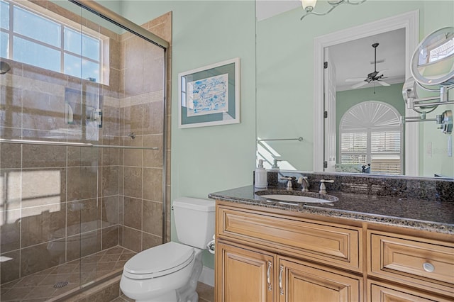 bathroom featuring plenty of natural light, ceiling fan, toilet, and walk in shower