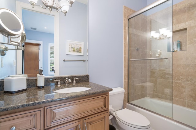 full bathroom with combined bath / shower with glass door, toilet, and vanity