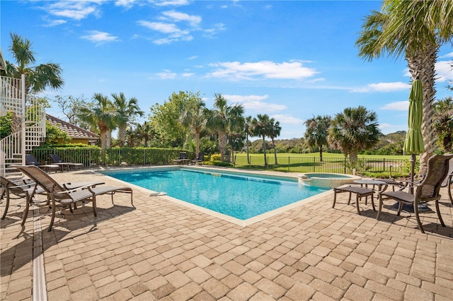 view of swimming pool featuring a patio area and an in ground hot tub