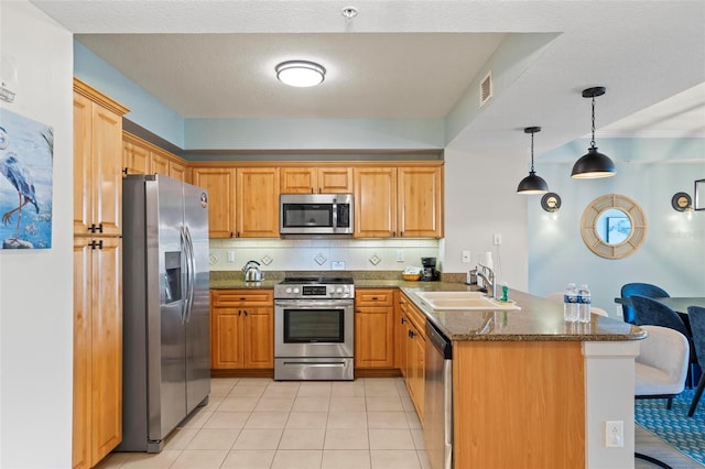 200 Ocean Crest Dr Unit 515, Palm Coast, FL 32137 - kitchen featuring appliances with stainless steel finishes, a peninsula, dark stone counters, decorative light fixtures, and light tile patterned flooring