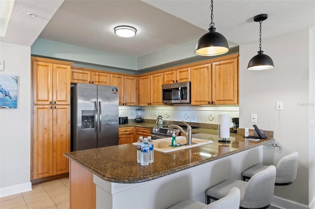 kitchen with tasteful backsplash, kitchen peninsula, a kitchen breakfast bar, and appliances with stainless steel finishes