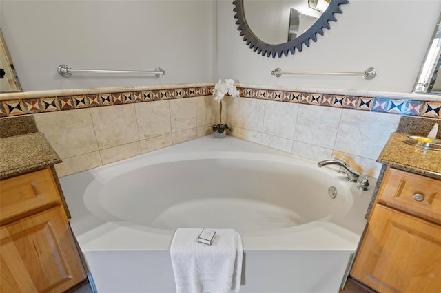 bathroom featuring vanity and a relaxing tiled tub