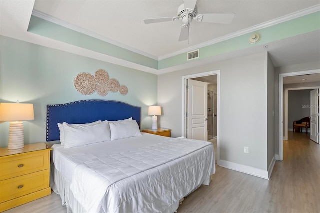 bedroom with connected bathroom, ceiling fan, light hardwood / wood-style flooring, and crown molding