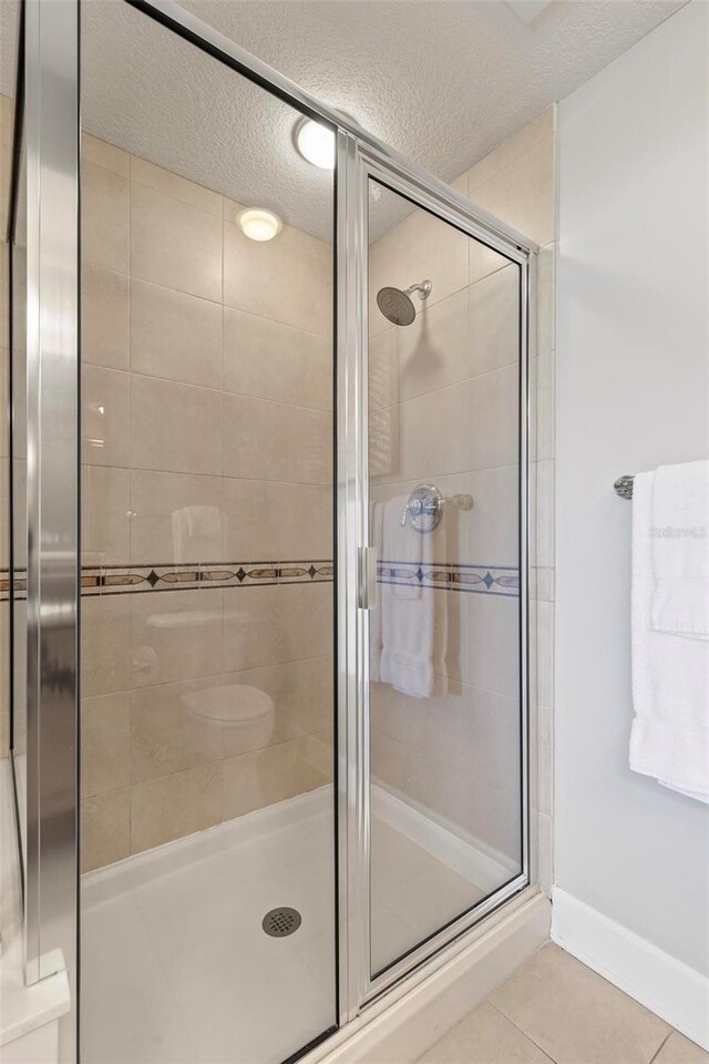 200 Ocean Crest Dr Unit 515, Palm Coast, FL 32137 - full bath featuring a textured ceiling, a shower stall, and tile patterned flooring