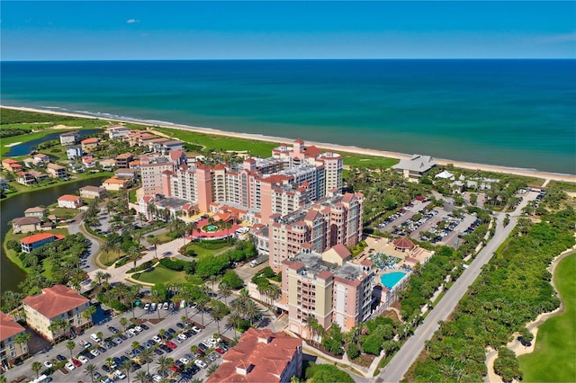 birds eye view of property with a water view and a beach view